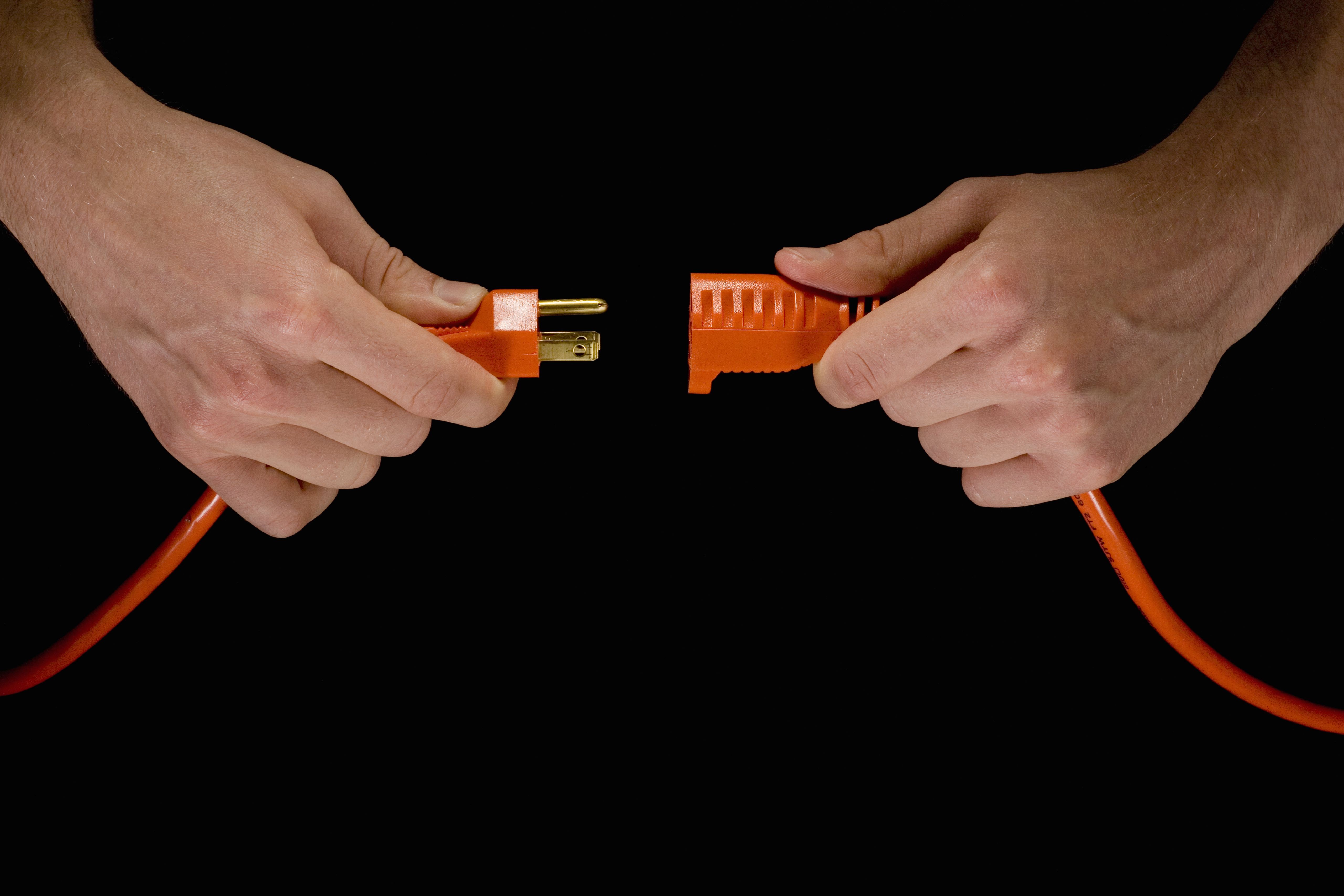 man holding electric plug and extension cord studio shot close up of hands sb aa 001 5b6f95bac9e77c0025d69c87